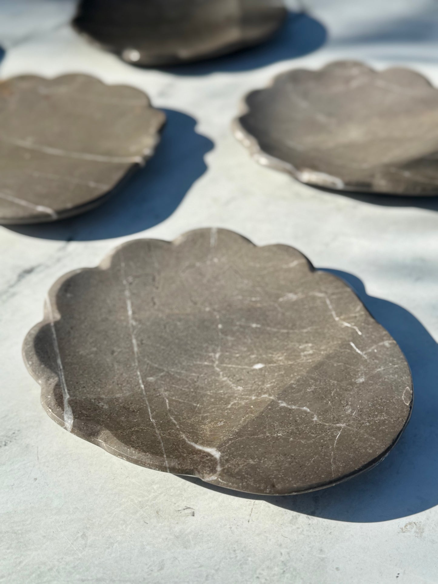 Close-up of scalloped edge detail on handcrafted gray marble spoon rest