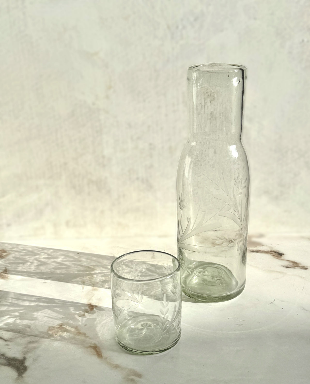 Close-up of etched pattern on recycled glass tall carafe showcasing handmade craftsmanship